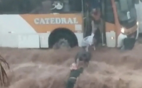 Passageiros de ônibus fazem 'cordão humano' para salvar motociclista que era arrastado por enxurrada 