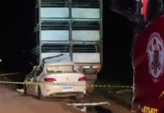 Motorista morre após carro bater em carreta e ficar preso na traseira do veículo
