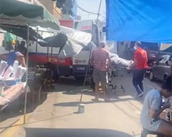 Feira bloqueia entrada de hospital e paciente é carregado em meio a barracas no ES