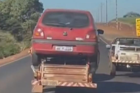 Carro é transportado em cima de carretinha em rodovia